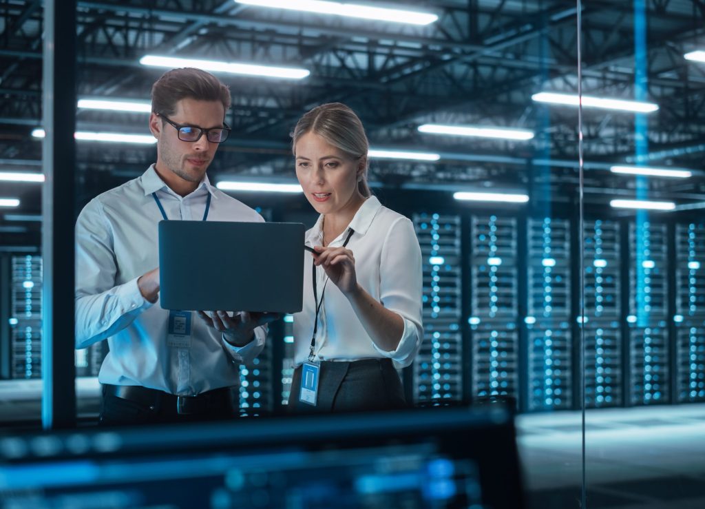 Male CEO Discusses Problem Solving with Female Partner in Office, They Brainstorming while Look on a Laptop. Smart Businesspeople Working in Finance. Specialists Work in Team Concept